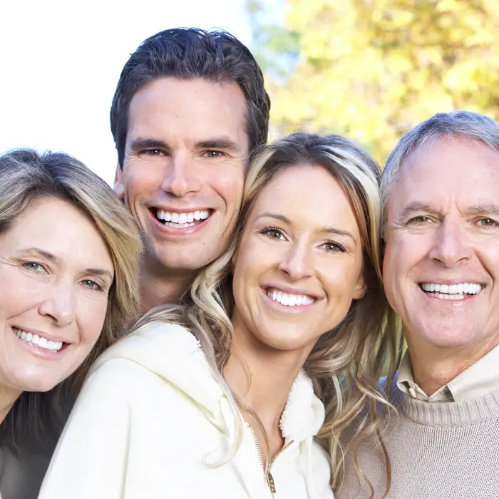 An intergenerational family smiling together