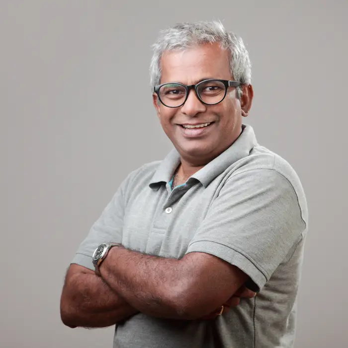 A middle-aged man wearing glasses and smiling